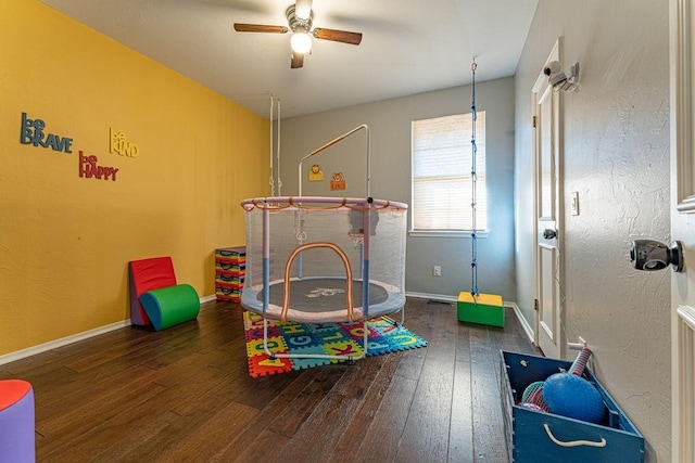 playroom featuring baseboards, hardwood / wood-style floors, and a ceiling fan