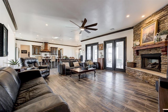 living area featuring a ceiling fan, ornamental molding, a fireplace, recessed lighting, and dark wood-style flooring