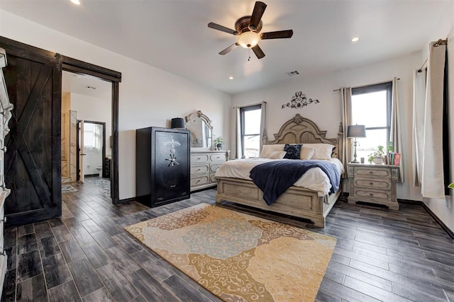 bedroom featuring multiple windows, a barn door, dark wood-style floors, recessed lighting, and a ceiling fan