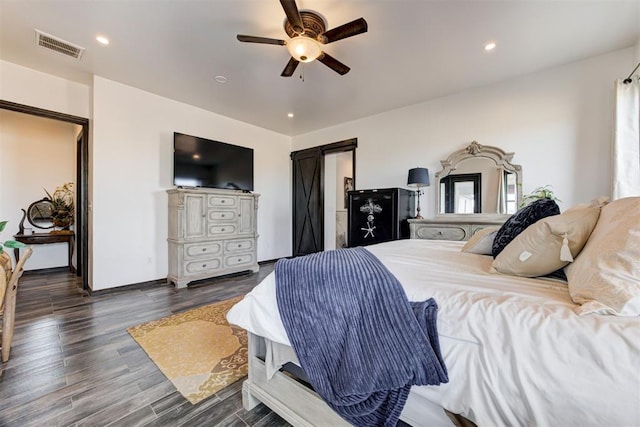 bedroom featuring wood finished floors, a barn door, a ceiling fan, baseboards, and recessed lighting