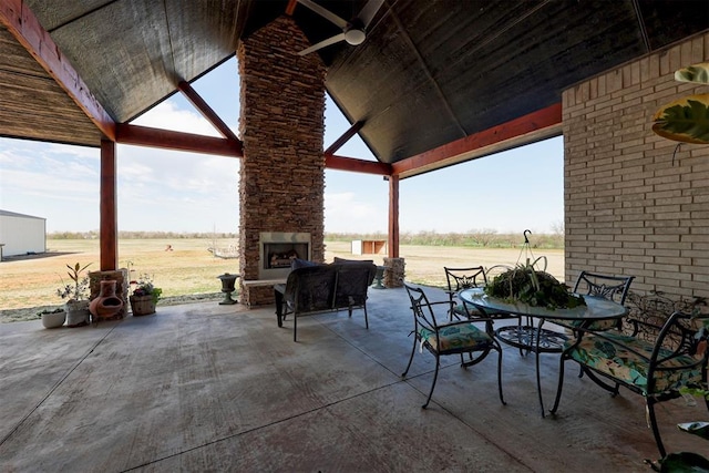 view of patio with an outdoor stone fireplace and a gazebo