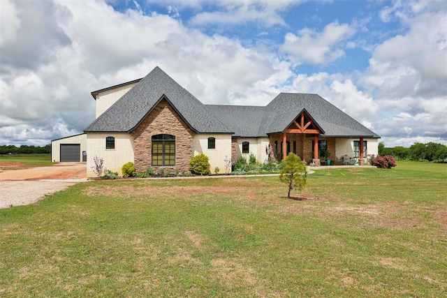 craftsman house with driveway, stone siding, a front yard, roof with shingles, and a detached garage