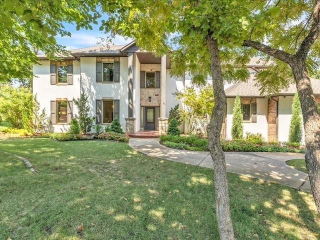 view of front of house featuring stucco siding and a front yard