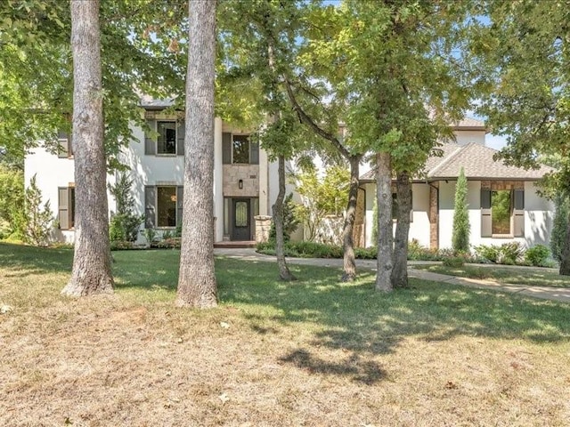 view of front of house with a front yard and stucco siding