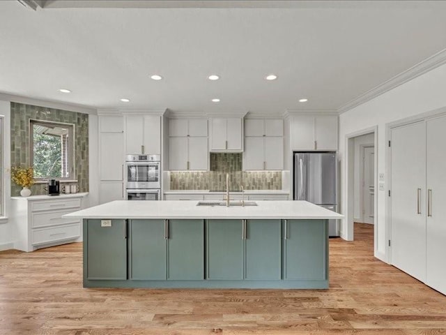 kitchen with white cabinets, green cabinetry, light countertops, and appliances with stainless steel finishes