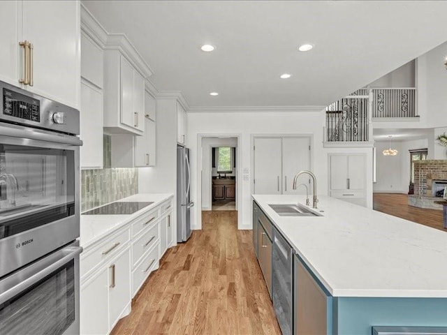 kitchen featuring light countertops, backsplash, a sink, stainless steel appliances, and white cabinets