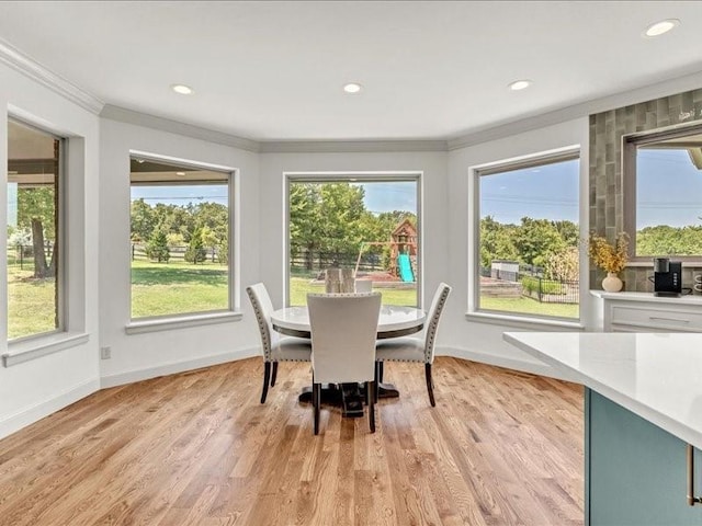 dining space with baseboards, light wood-type flooring, and crown molding