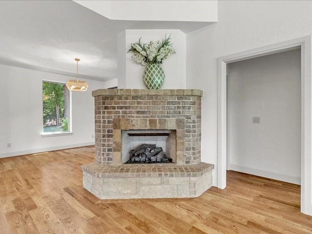 interior details with baseboards, a fireplace, crown molding, and wood finished floors