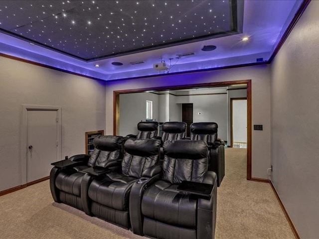 carpeted cinema featuring a raised ceiling, baseboards, and visible vents