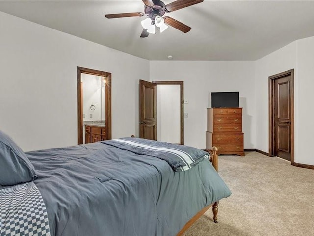 bedroom with a ceiling fan, ensuite bath, baseboards, and light colored carpet
