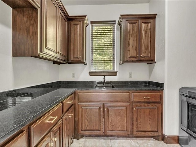 kitchen featuring a sink and dark stone countertops