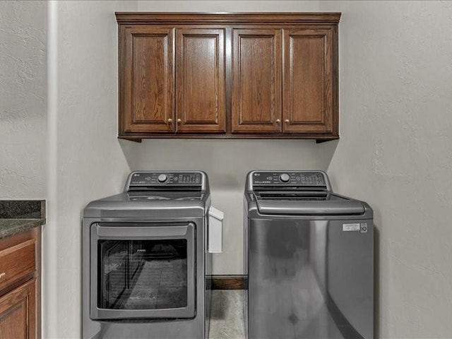 laundry area with separate washer and dryer and cabinet space