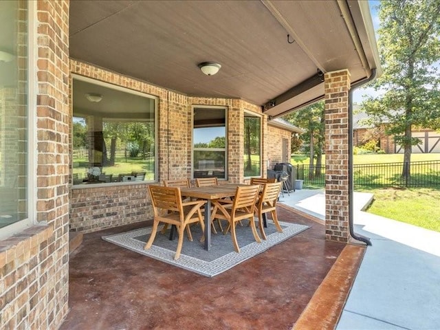 view of patio featuring outdoor dining area and fence