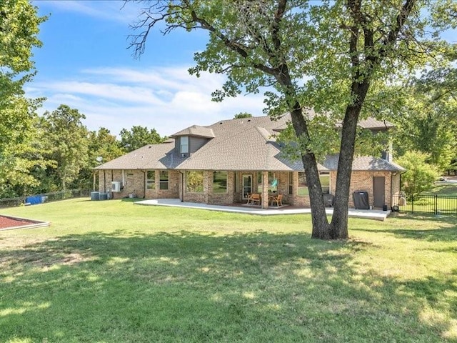 back of property featuring a patio area, a lawn, and fence