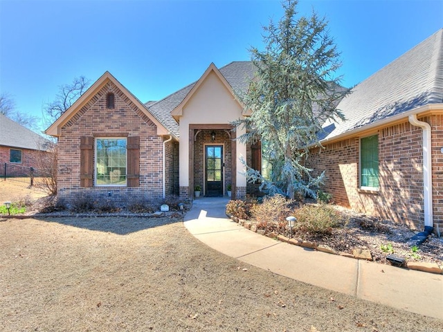 view of front of home with brick siding and a shingled roof