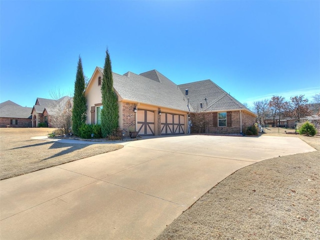 view of side of home featuring brick siding, driveway, and an attached garage