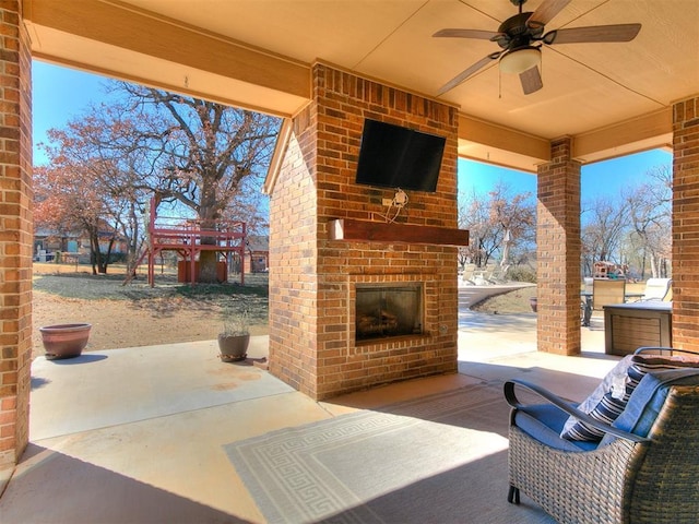 view of patio / terrace with an outdoor living space with a fireplace and a ceiling fan