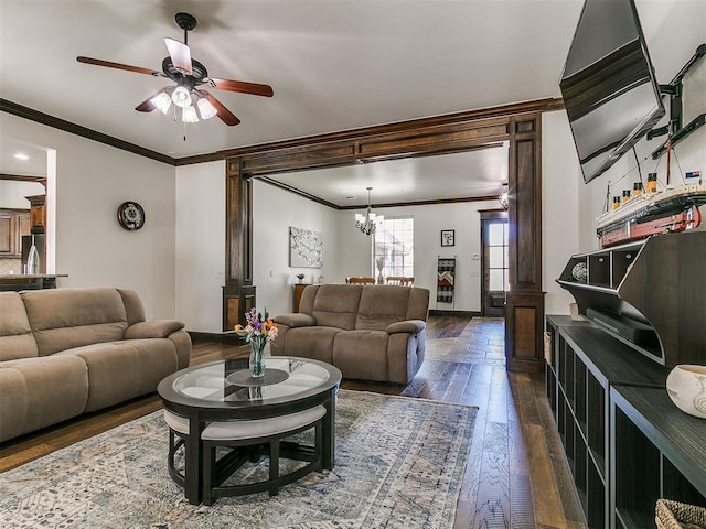 living area featuring ceiling fan with notable chandelier, baseboards, ornamental molding, and hardwood / wood-style flooring