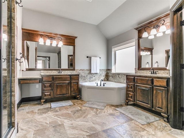 bathroom with vaulted ceiling, a bath, a wealth of natural light, and a sink