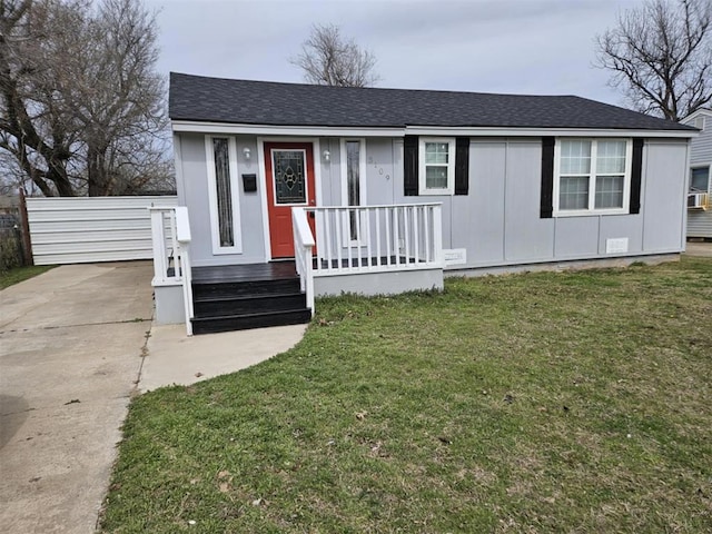 view of front of house featuring driveway, roof with shingles, and a front lawn