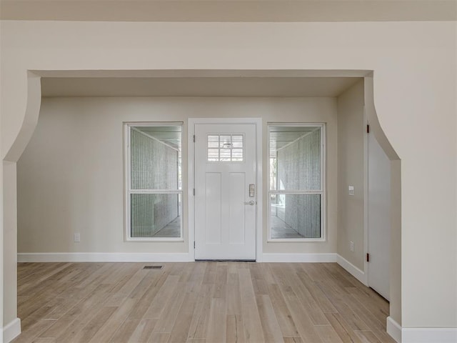 foyer featuring light wood-style flooring, baseboards, and visible vents