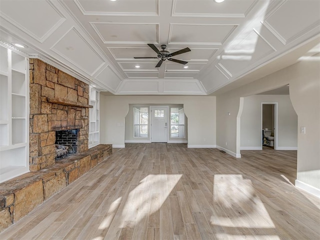 unfurnished living room with light wood-style floors, baseboards, coffered ceiling, and a stone fireplace