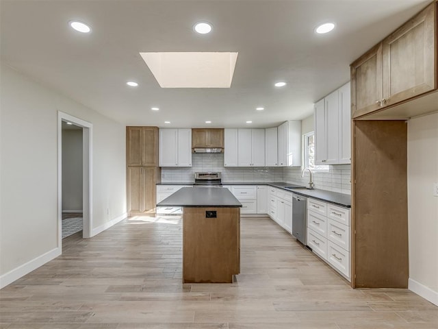 kitchen featuring a sink, dark countertops, backsplash, a center island, and stainless steel appliances