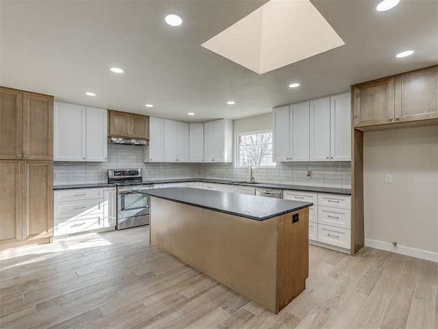 kitchen with dark countertops, light wood finished floors, and stainless steel appliances