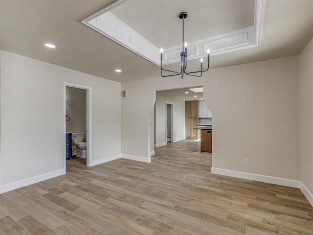 interior space featuring recessed lighting, light wood-type flooring, baseboards, and a notable chandelier