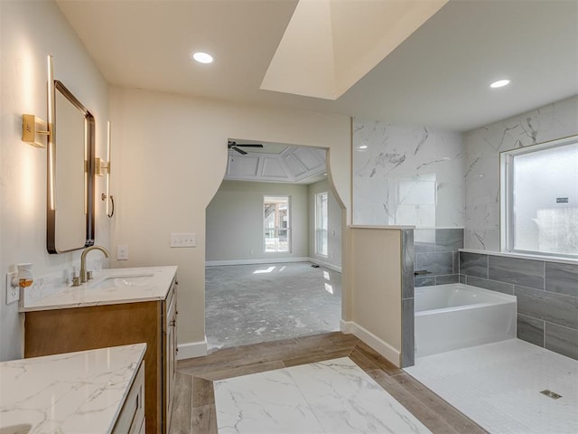 full bath featuring recessed lighting, baseboards, a bath, and vanity