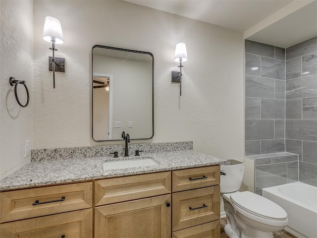 full bathroom with vanity, toilet, a textured wall, and shower / bath combination