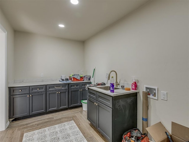 kitchen featuring a sink, light countertops, and light wood finished floors