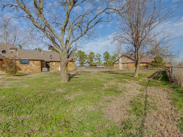 view of yard with central air condition unit and fence