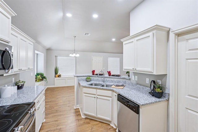 kitchen with light wood finished floors, visible vents, appliances with stainless steel finishes, a peninsula, and an inviting chandelier