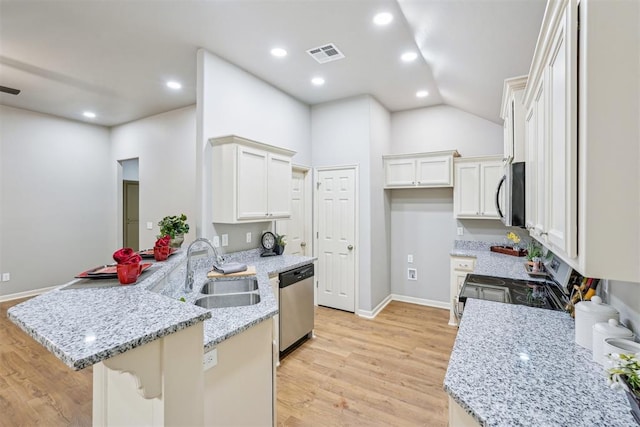 kitchen with visible vents, light wood-type flooring, a peninsula, stainless steel appliances, and a sink