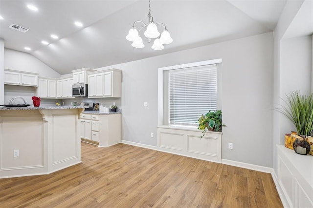 kitchen featuring visible vents, lofted ceiling, stainless steel microwave, light wood-type flooring, and a chandelier