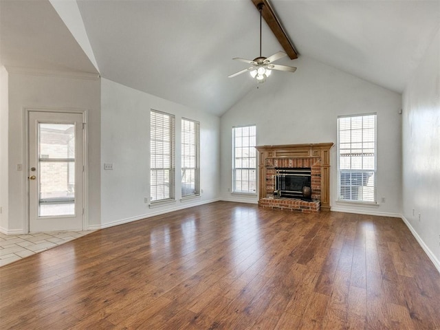 unfurnished living room featuring hardwood / wood-style floors, beamed ceiling, and a healthy amount of sunlight