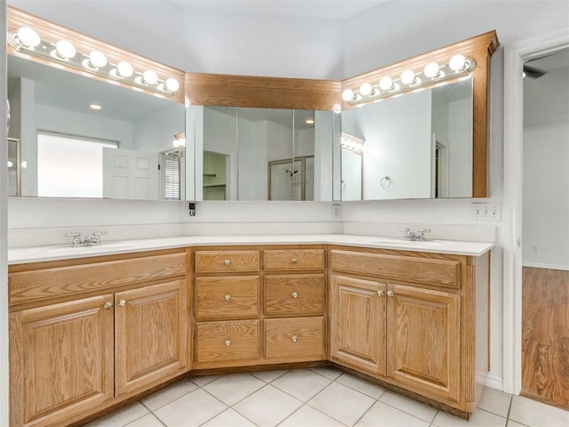 full bathroom with a sink, double vanity, and tile patterned floors