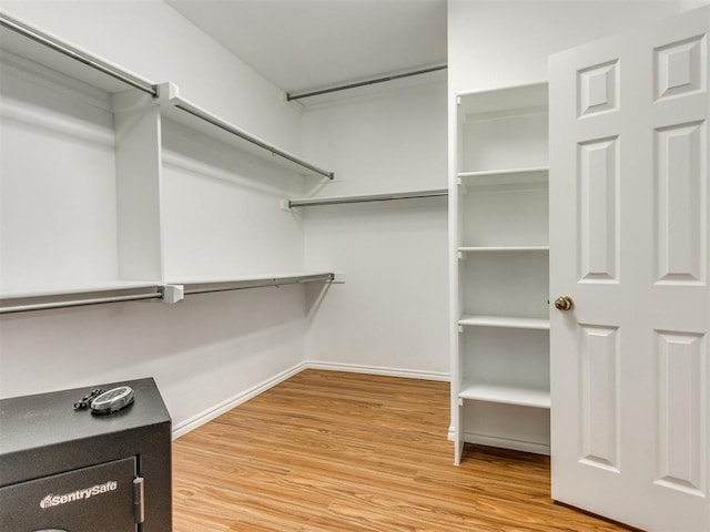 walk in closet with wood finished floors