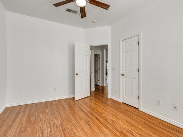 unfurnished bedroom featuring light wood-type flooring, baseboards, visible vents, and a ceiling fan