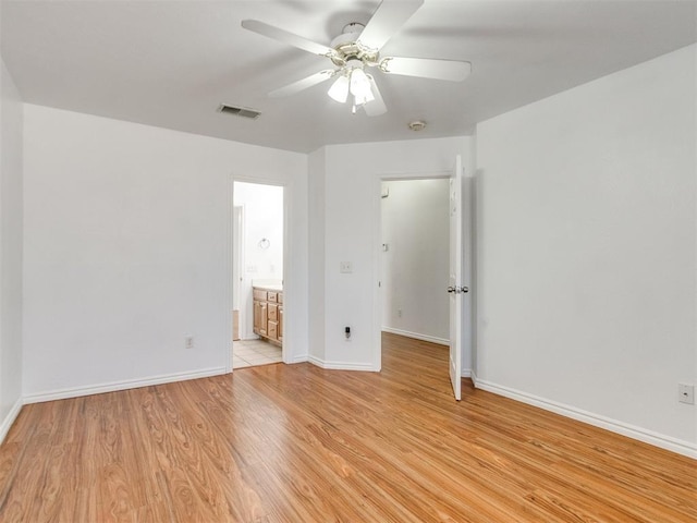 unfurnished bedroom with visible vents, baseboards, ensuite bathroom, light wood-style floors, and a ceiling fan