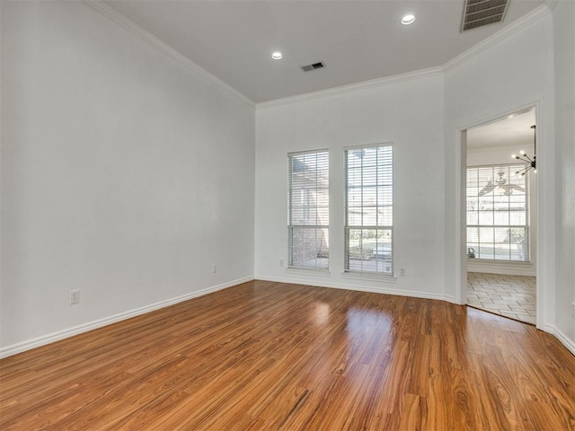 spare room featuring visible vents, crown molding, and wood finished floors