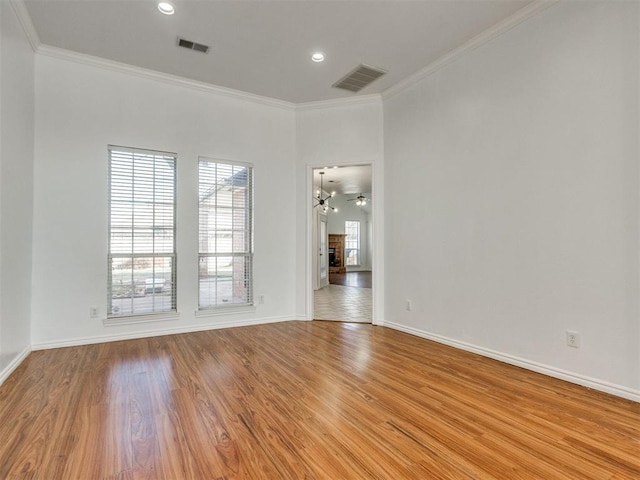 spare room featuring crown molding, wood finished floors, and visible vents