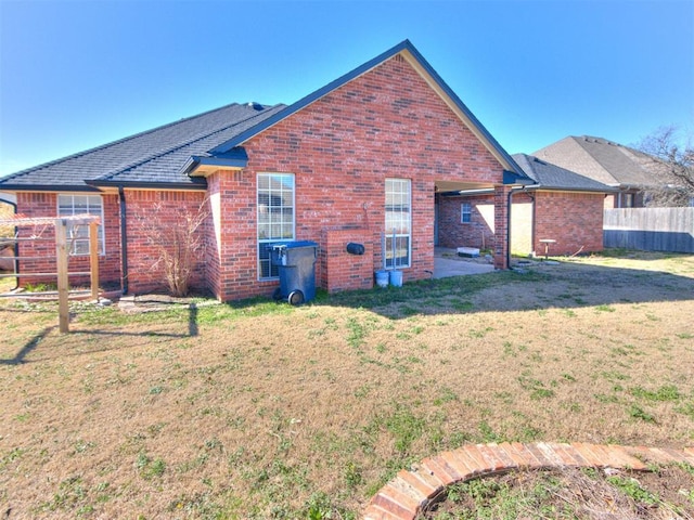 back of house with a patio, a yard, fence, and brick siding