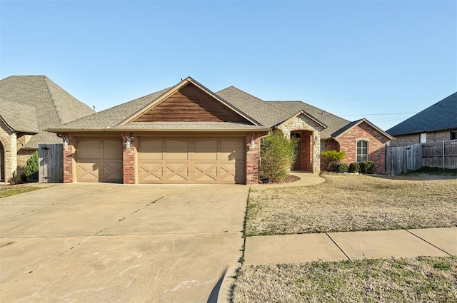 view of front of property featuring an attached garage, fence, and brick siding