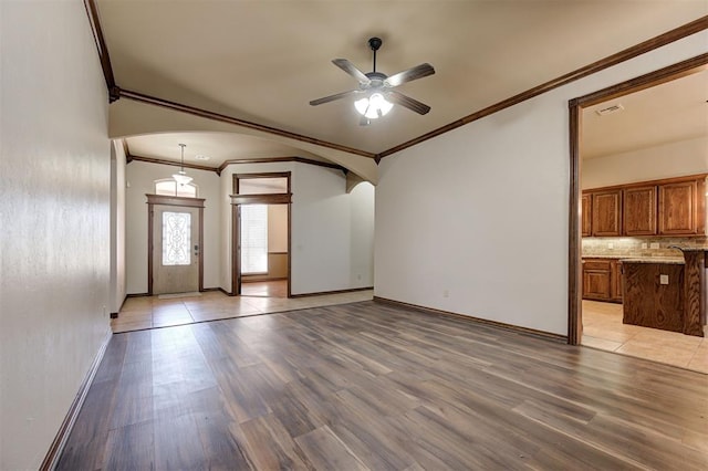 unfurnished living room featuring a ceiling fan, visible vents, baseboards, arched walkways, and light wood-type flooring