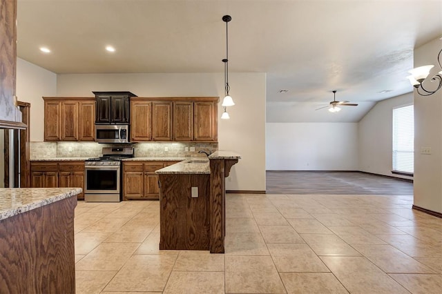 kitchen with stainless steel appliances, tasteful backsplash, a peninsula, and ceiling fan