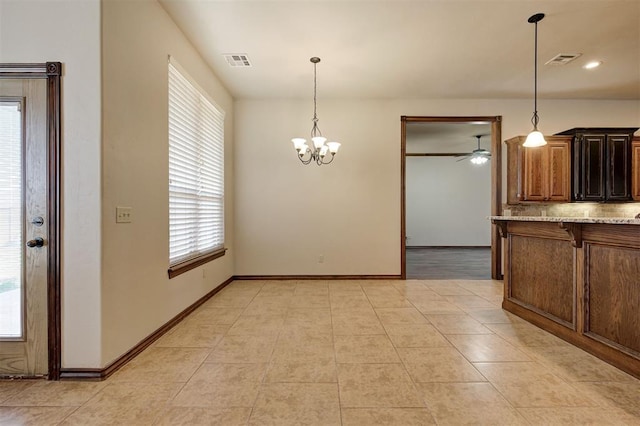 unfurnished dining area with light tile patterned floors, visible vents, and ceiling fan with notable chandelier