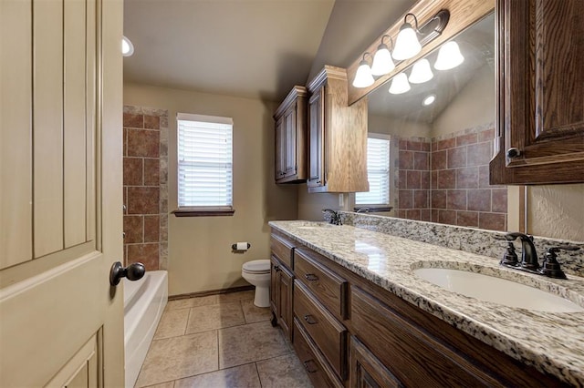 bathroom with a sink, toilet, double vanity, and vaulted ceiling