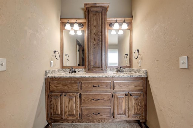 full bathroom with a sink, double vanity, and a textured wall